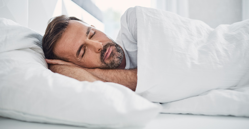 Beraterin und Kundin beim Probeliegen einer Matratze.